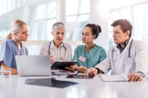 Group of doctors working together on a medical chart at doctor's office.