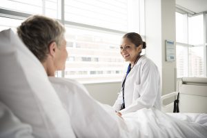 Female doctor in hospital consulting with senior patient